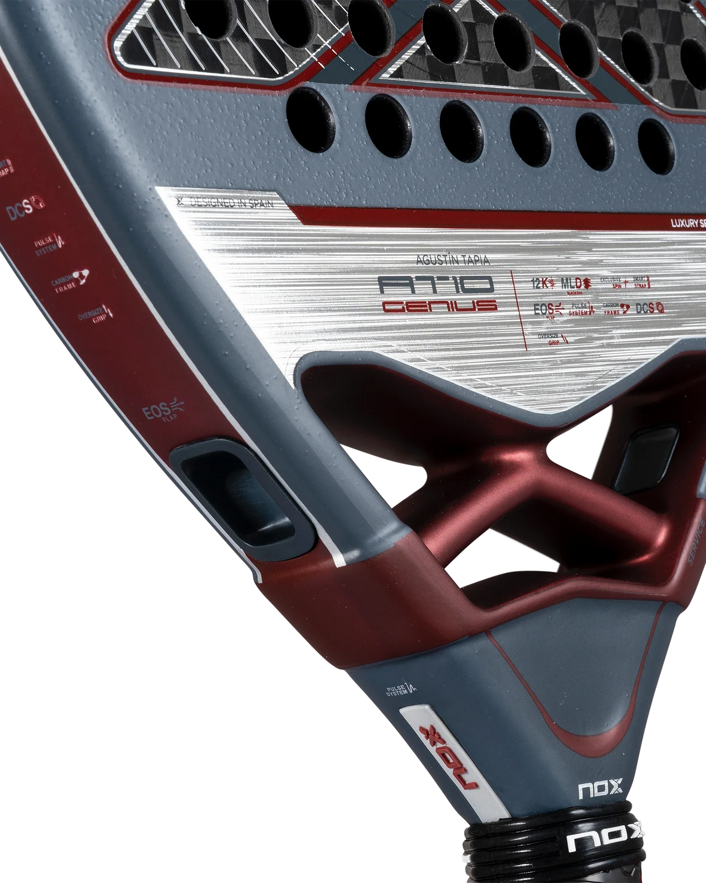 Close-up of the Nox AT10 Luxury GENIUS 12K 2025 by Agustin Tapia for Padel USA, featuring a textured grey and maroon 12K carbon fiber face, exclusive spin tech, perforations, logos, specs, metallic finishes, and an advanced angular design.