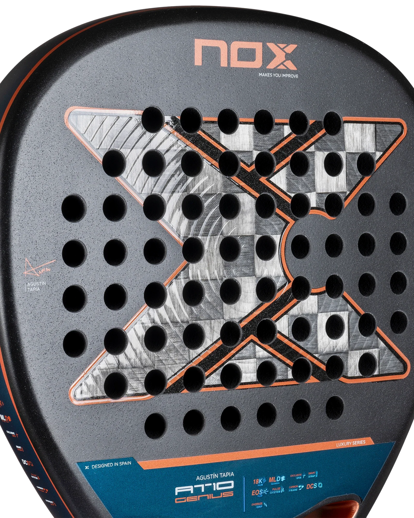 Close-up of the Nox AT10 Luxury GENIUS ATTACK 18K Alum 2025 by Agustin Tapia from Padel USA, showing its diamond-shaped head, X-shaped metallic pattern, circular holes, orange and silver accents, and specs near the base. Crafted with 18K aluminized carbon.