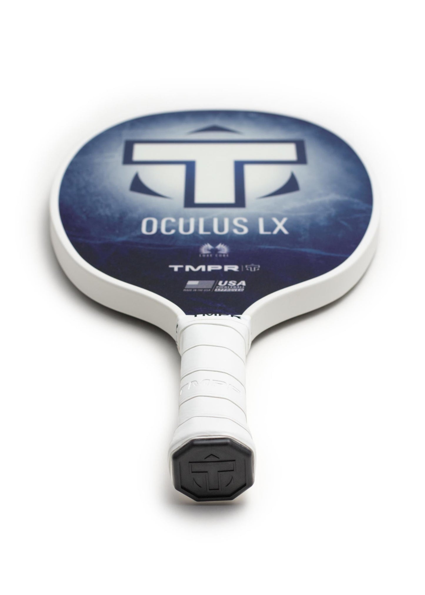 A close-up of the TMPR Sports Oculus LX | Indigo Ice pickleball paddle shows its blue and white face with TMPR logo, neatly wrapped white grip, and raised end cap logo—this limited edition stands out on a white background.