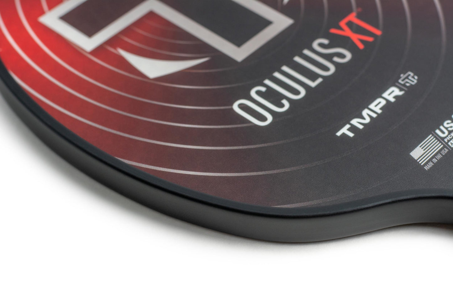 Close-up of the TMPR Sports Oculus XT paddle with a red and black gradient. The paddle displays OCULUS XT, TMPR, and the USA Pickleball approval logo. It provides excellent spin control with its smooth, glossy surface.