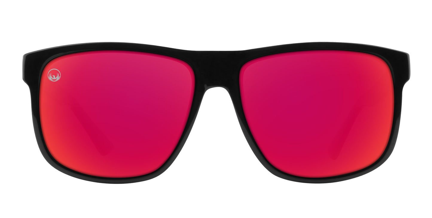 The Cinder sunglasses from Neven Eyewear’s Phoenix Collection feature a thick black frame, large maroon mirrored polarized lenses, and a small white logo on the left lens for a sporty, modern style.