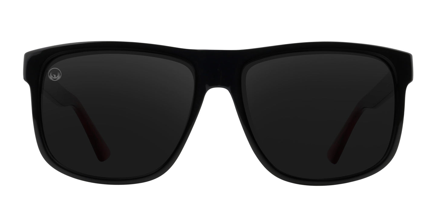 The Neven Eyewear Ignite sunglasses feature a black rectangular frame with dark tinted lenses, thick plastic arms, and a small circular logo. Shown from the front on white, they offer polarized UV400 protection for optimal eye safety.