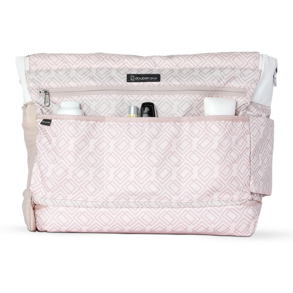 The Doubletake PARISII Pickleball Tote features a light pink geometric pattern, multiple front pockets for baby items like bottles and containers, a top zipper pocket, and a fabric handle on the left side.