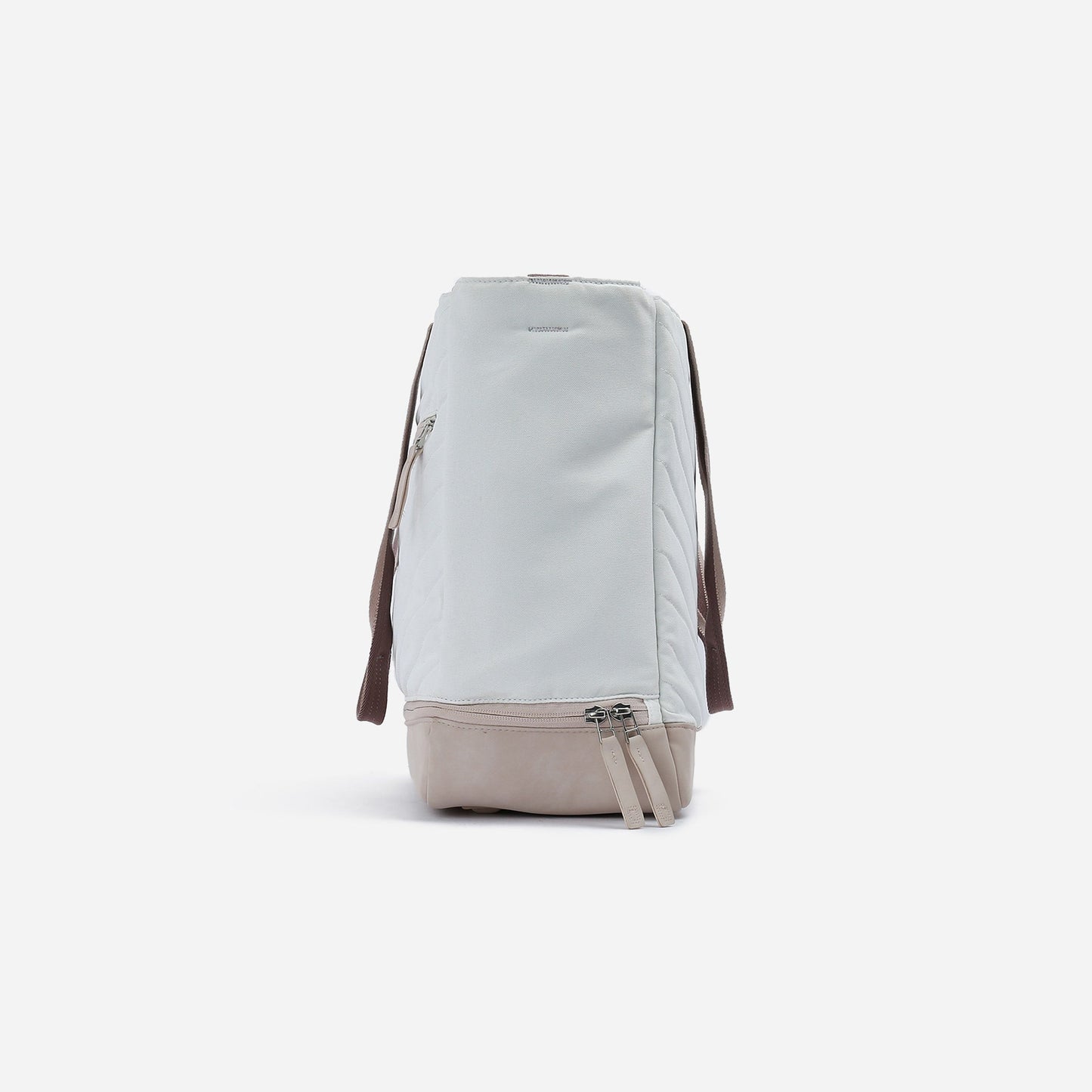 Side view of the Doubletake PARISII | Pickleball Tote in light grey, featuring brown shoulder straps, a beige bottom panel, and zippered side pocket. The paddle bag stands upright on a white background, highlighting its zippers and side profile.