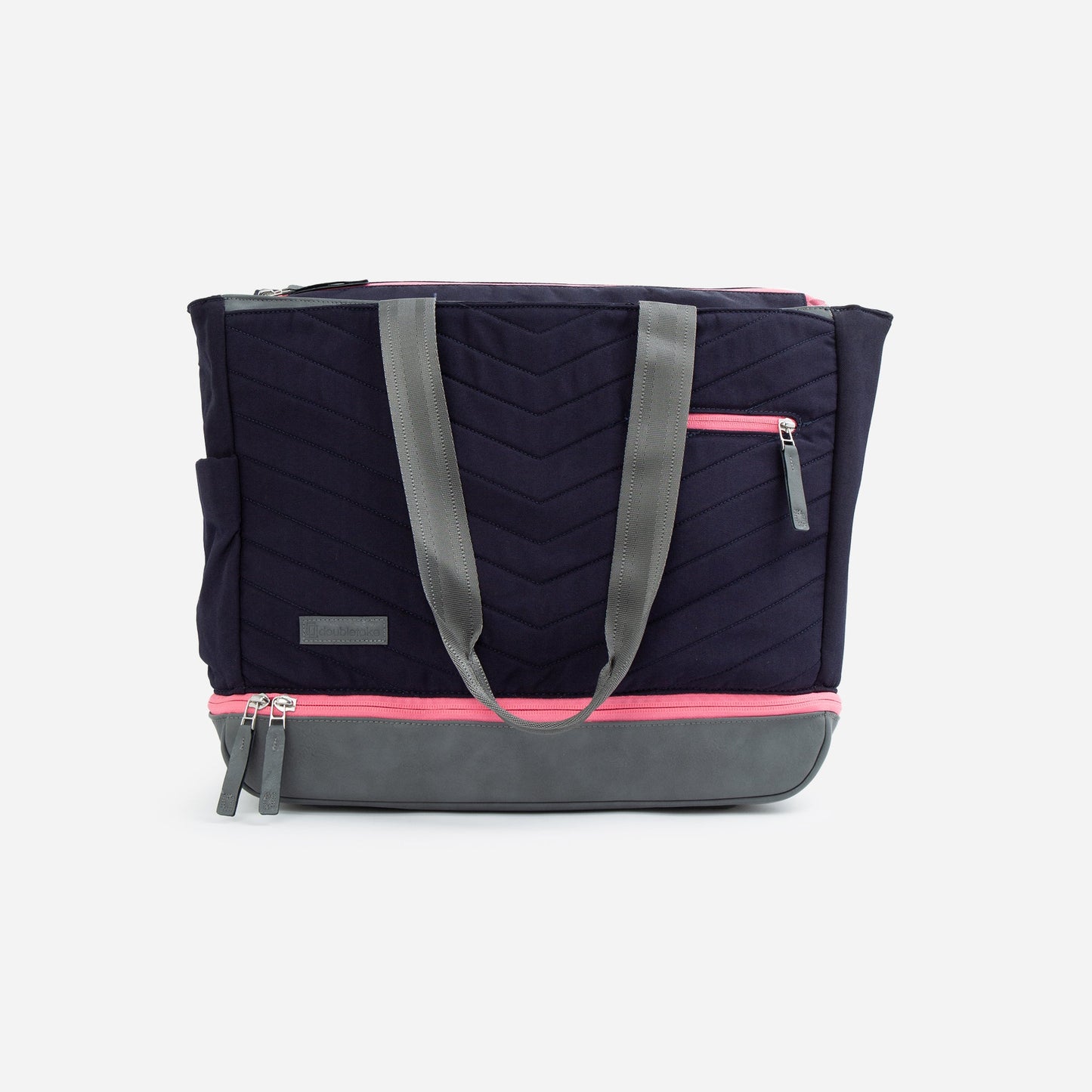 The PARISII | Pickleball Tote by Doubletake is a navy blue bag with quilted chevron stitching, gray handles and base, plus pink zippers on the top, front pocket, and bottom compartment. It stands upright against a plain white background.