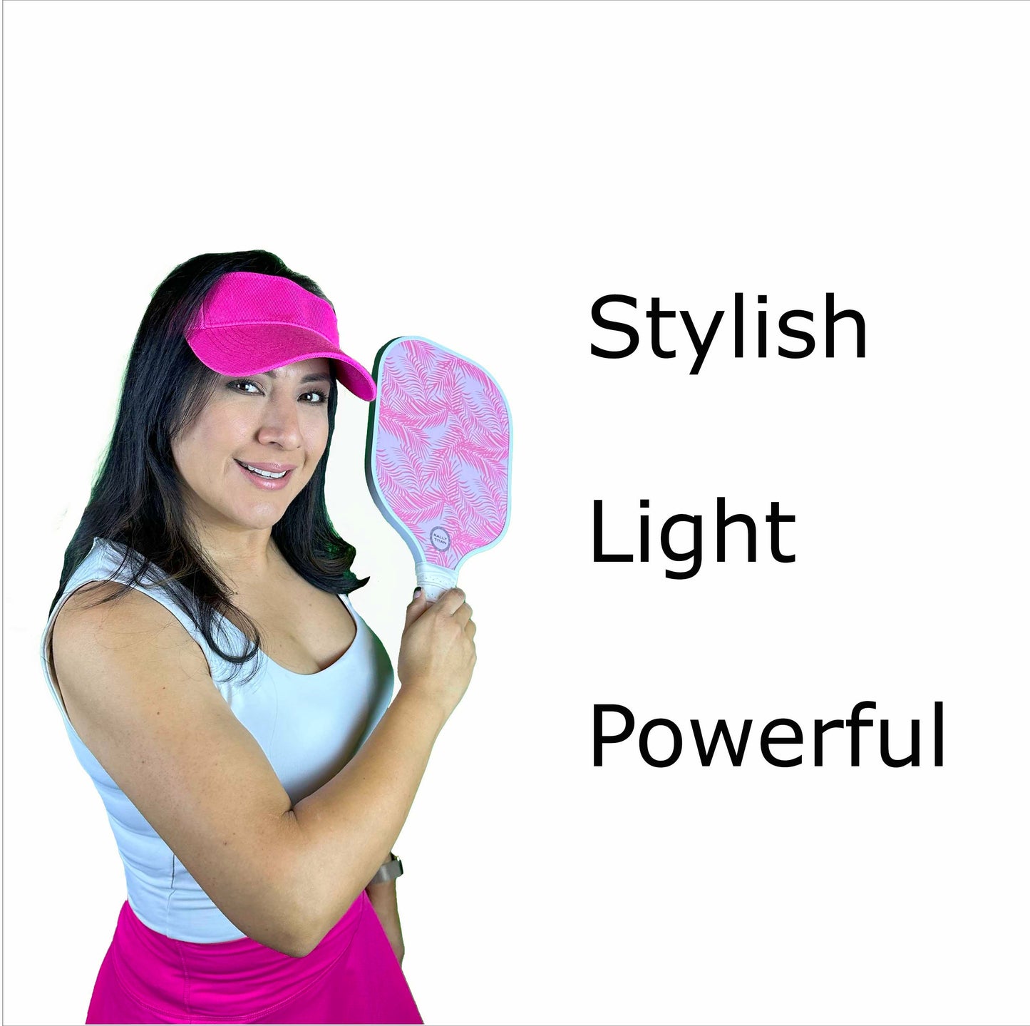A woman in a pink visor and skirt, with a white tank top, smiles while holding the Malibu | 10MM T300 Textured Carbon Fiber Surface paddle from Rally Titan Pickleball. "Stylish, Light, Powerful" appears in black text on a white background beside her.