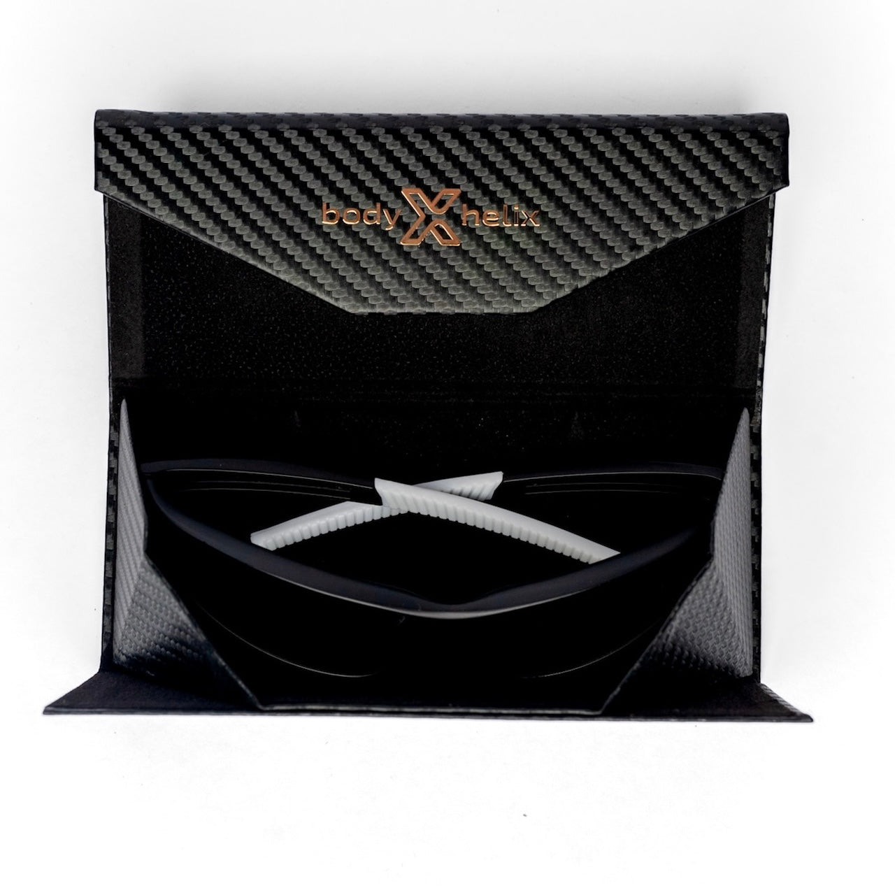 A black, carbon fiber-patterned body helix case with gold lettering is open to reveal Pickleball Glasses inside. The white arms rest atop the lenses, offering eye protection and style against a white background.