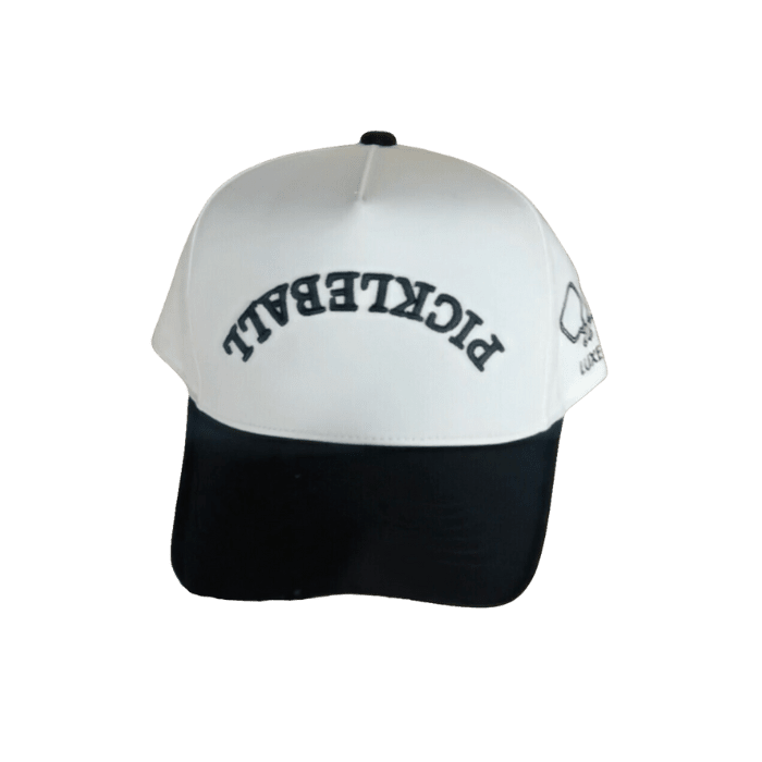 The LUXE Pickleball Hat is a stylish snapback with bold “PICKLEBALL” lettering on the white front, a black brim and base for sun protection, and a small pickleball paddle and ball graphic on the side.