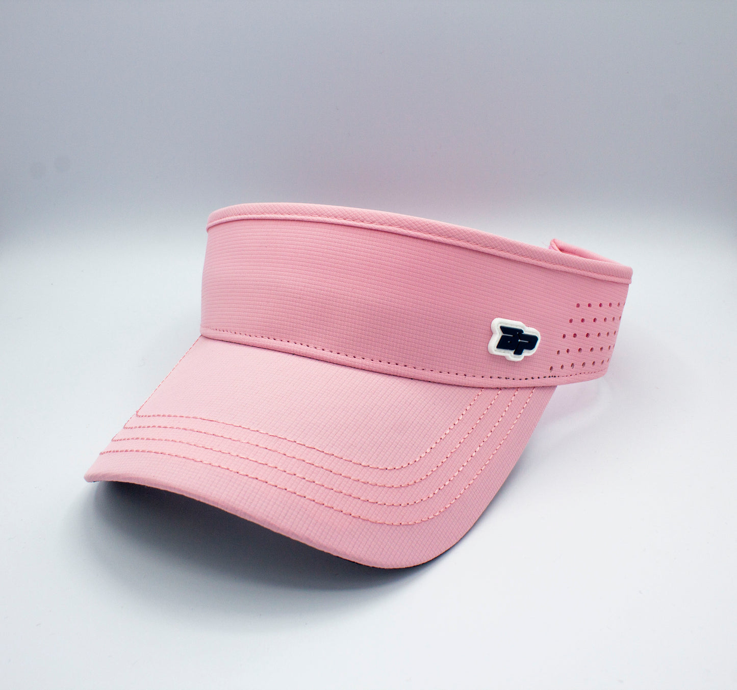 The Bodhi Performance ICON Visor in light pink features visible stitching, a curved brim, and an adjustable fit. A small white and navy rectangular logo accents the front left. Shown on a plain white background, it's ideal for sports.