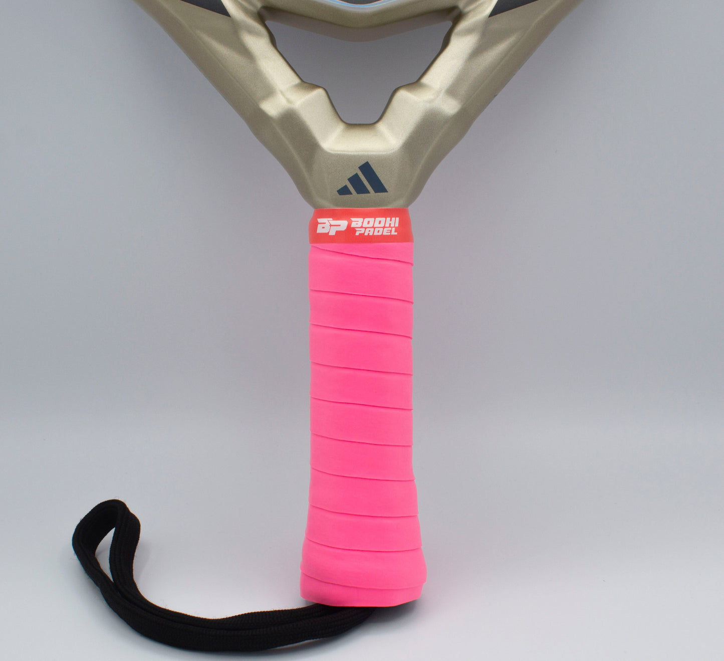 Close-up of a padel racket handle wrapped in bright pink PROtack™ Premium Padel Overgrips by Bodhi Performance, featuring strong moisture absorption, a black wrist strap, and logo near the top. Background is plain light gray.