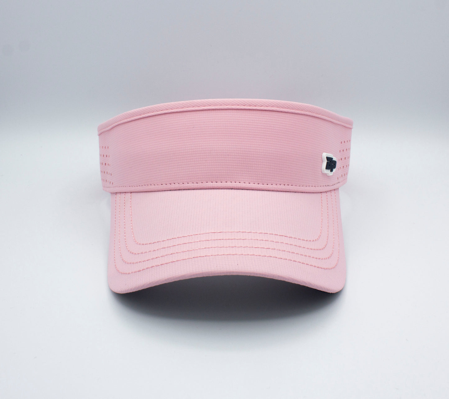 The Bodhi Performance ICON Visor, shown in light pink with a curved brim, features side ventilation holes and a dark and white emblem on the right band, displayed against a plain white background.