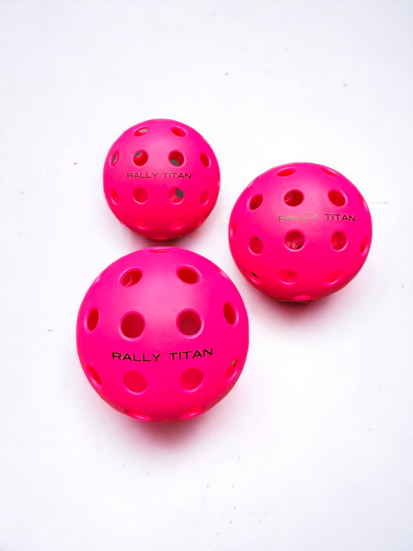 Rally Titan Pickleball Balls—set of 3 in pink—are fun, stylish accessories for any pickleball game.