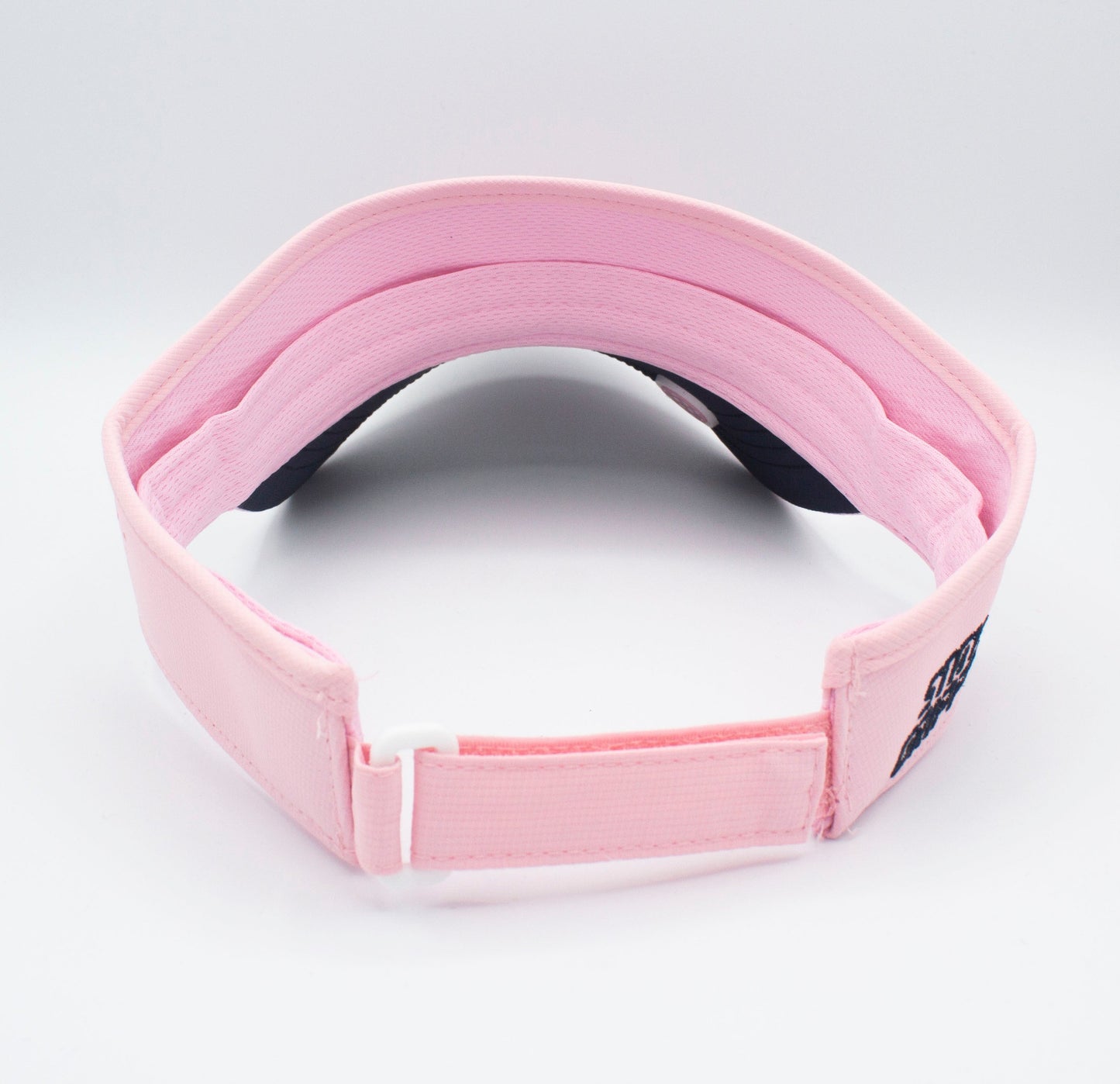 A light pink Bodhi Performance ICON Visor is shown from the back, highlighting its adjustable strap with white plastic buckle. The inner lining and headband are visible, with a dark underside on the brim, set against a plain white background.