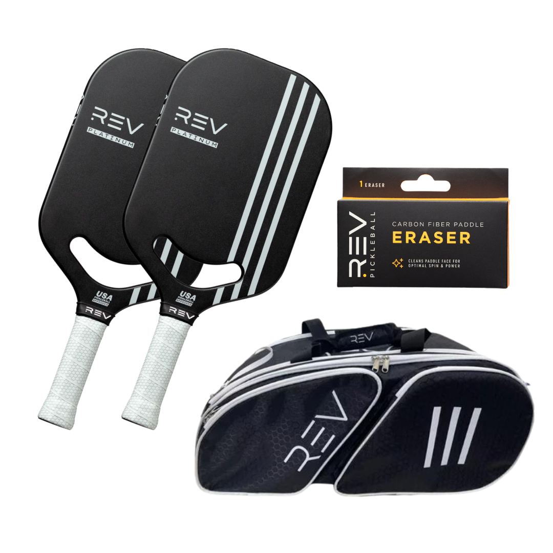 The Professional - Mix & Match - Bundle for 2 by REV Pickleball includes two black paddles with white handles, a carbon fiber paddle eraser in a box, and a black bag with white accents, all featuring the REV logo and modern design.