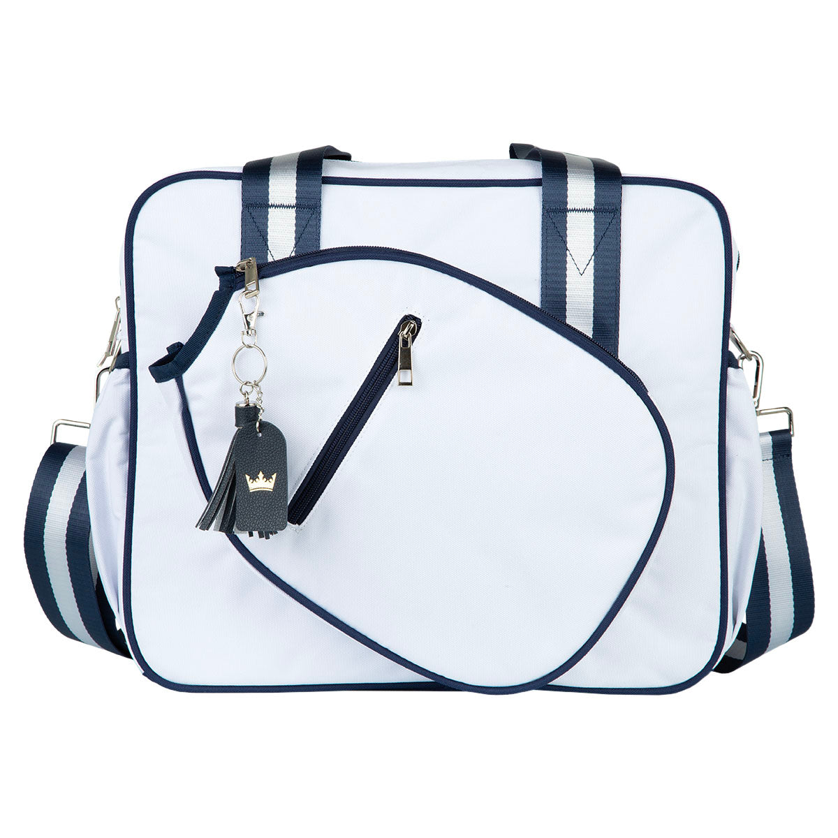 The Prepster Pickleball Bag by Queen of the Court is a square white tote with navy trim and straps, a large curved zip front pocket, detachable shoulder strap, and a black keychain with gold crown charm on the handle.