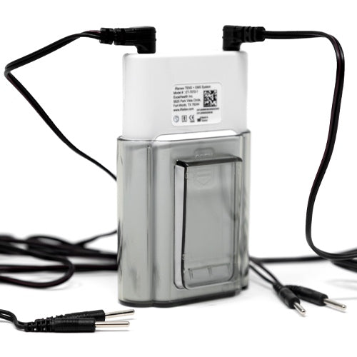 An iReliev TENS Unit Pain Relief System stands upright, featuring a rectangular design with a transparent lower compartment and top label. Black cables with metal plugs extend from the device for pain relief and soothing sore muscles against a white background.