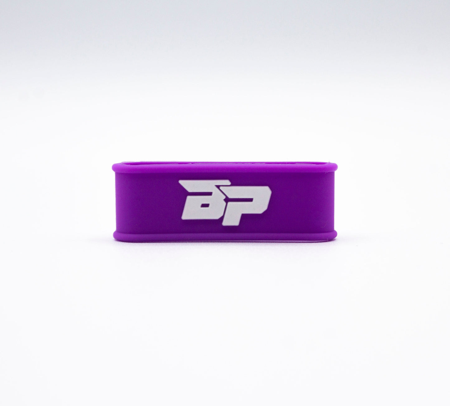 A rectangular purple silicone Paddle Band with rounded edges stands upright on a white background. The bold white Bodhi Performance BP logo marks it as an essential accessory to enhance your pickleball paddle with style.