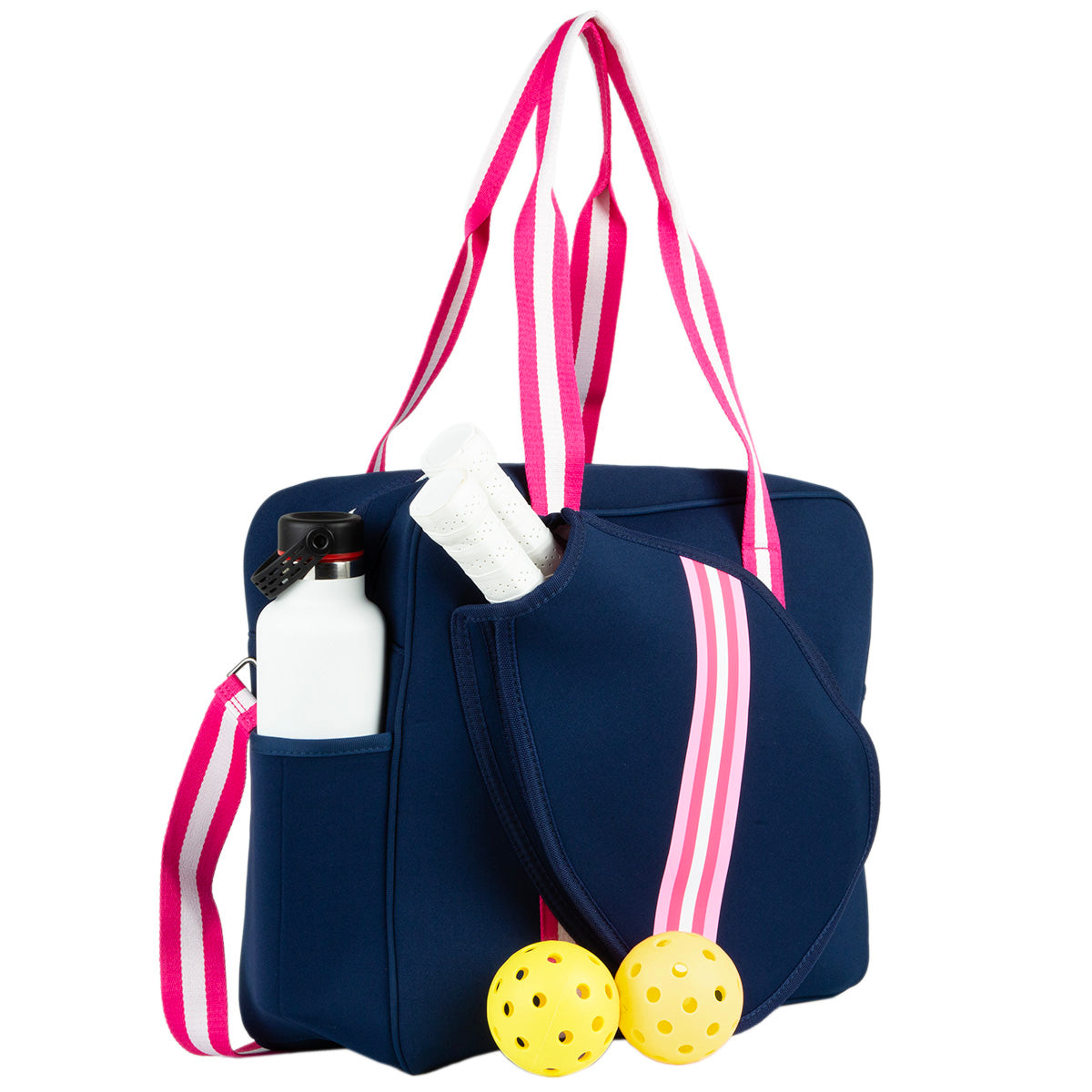 The Queen of the Court Brooklyn Pickleball Bag features navy blue neoprene with pink and white striped handles, holds two paddles, a white water bottle in the side pocket, and includes two yellow pickleballs placed in front.
