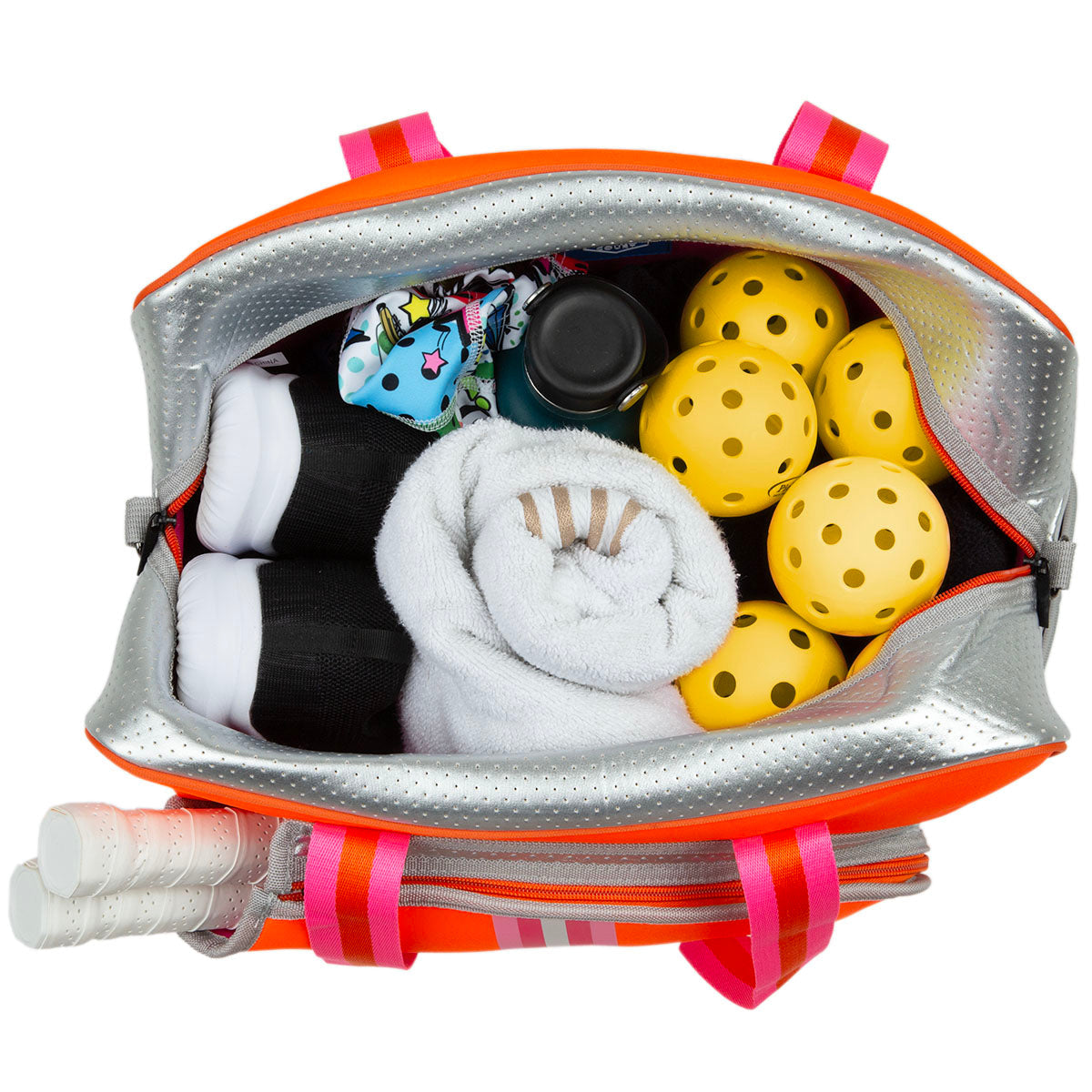A top-down view of the Queen of the Court Brooklyn Pickleball Bag shows yellow pickleballs, a rolled white towel, black water bottle, black clothes, white shoes, a colorful pouch inside, and two pickleball paddles with white handles in a side pocket.