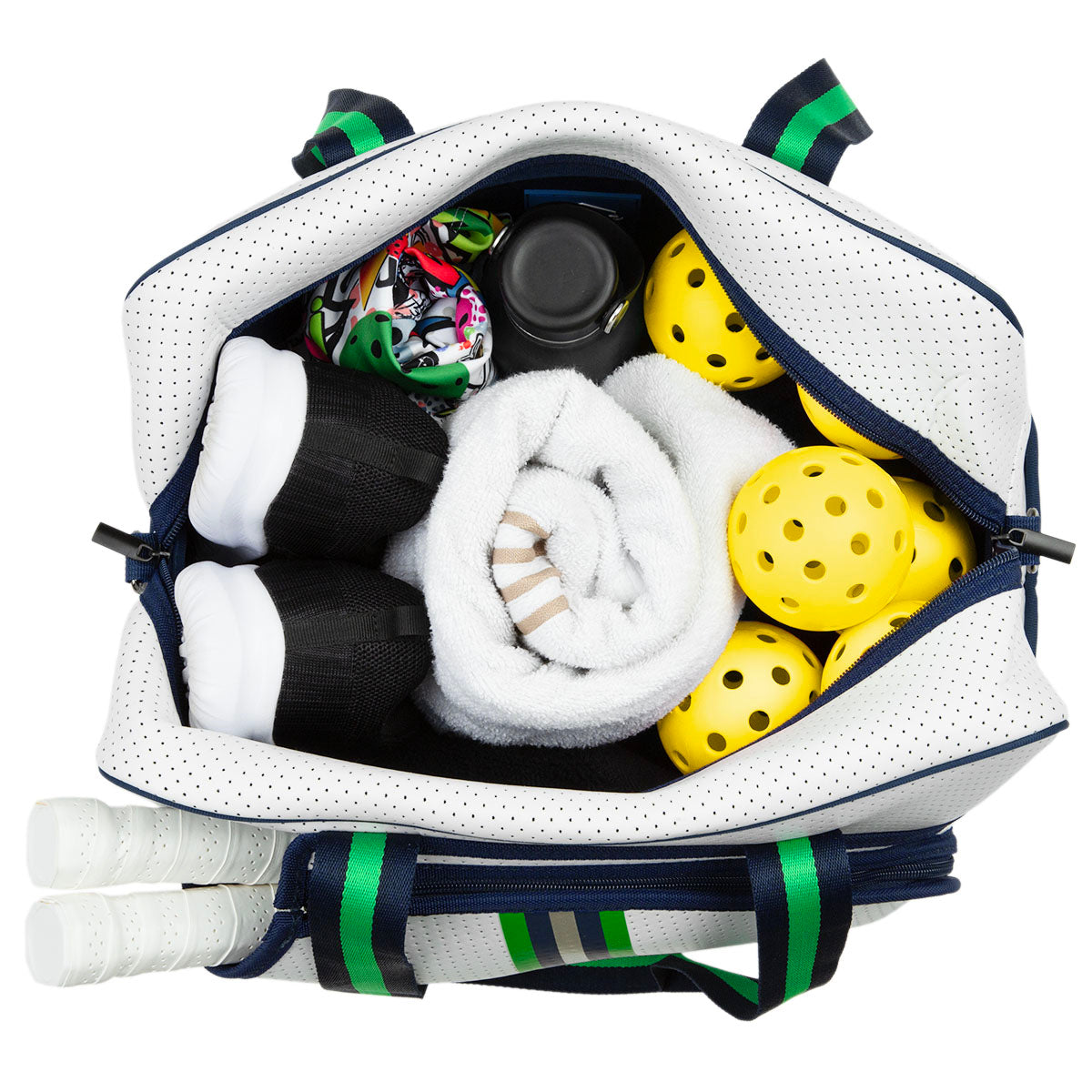 The Queen of the Court Brooklyn Pickleball Bag, shown from above, holds two paddles, six yellow pickleballs, white athletic shoes, a rolled towel, black water bottle, and a colorful pouch. The white bag has green and blue accents.