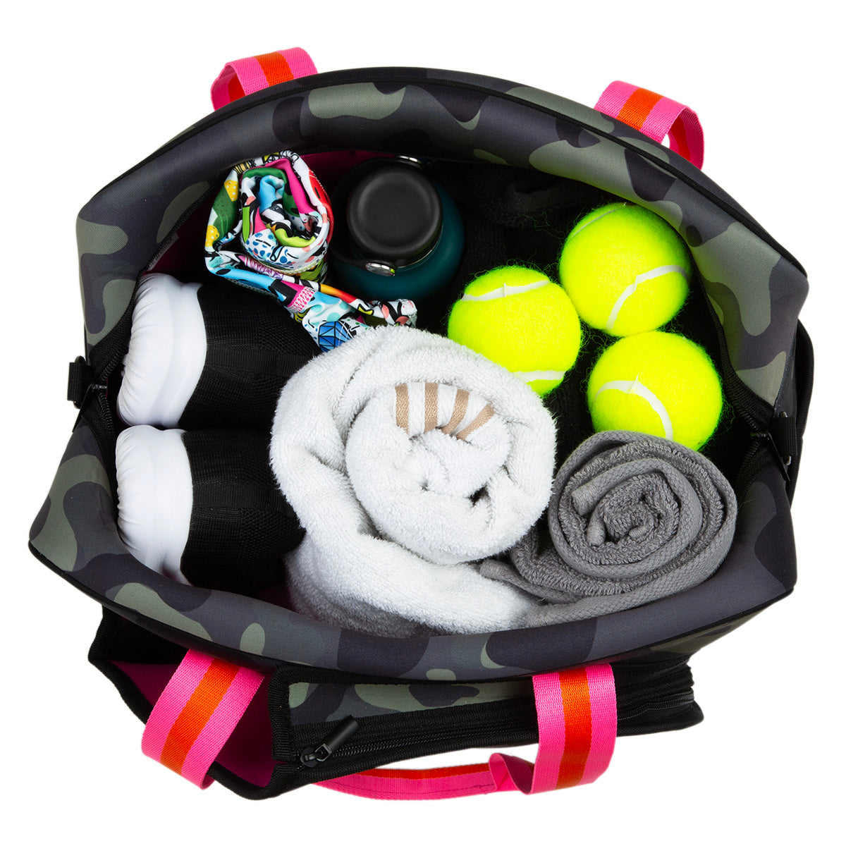 Top-down view of the Queen of the Court Hampton Tennis Bag in camouflage neoprene with pink handles, neatly packed with three tennis balls, a water bottle, rolled towels, black and white sneakers, a colorful cloth, and a small container.