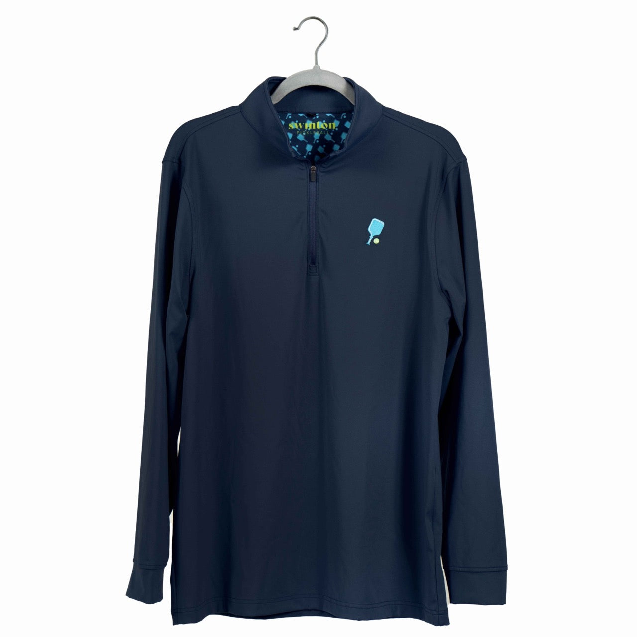 The Swinton Pickleball Court Performance Quarter Zip Pullover in Navy hangs on a hanger, showing a small blue paddle and ball graphic on the left chest and a light blue patterned inner collar lining.