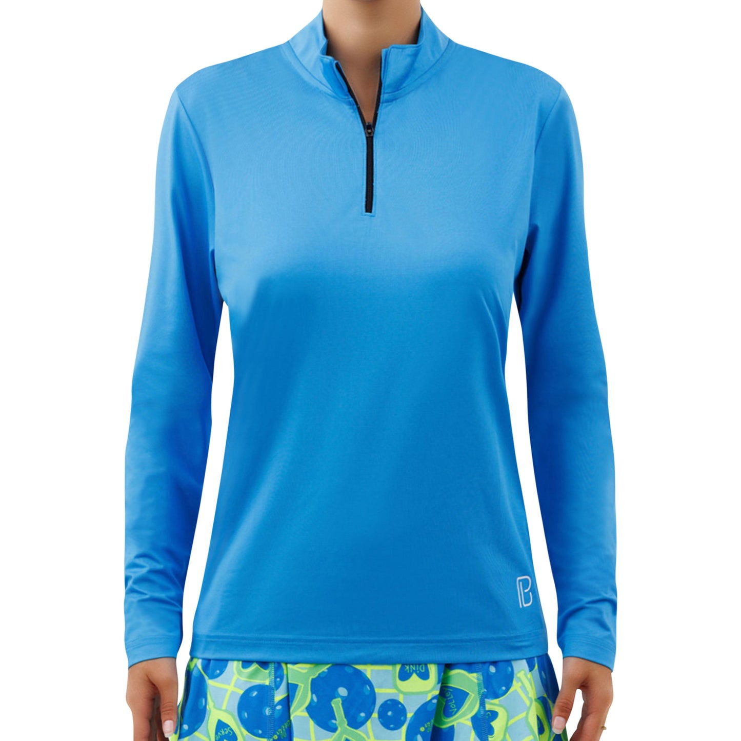 A person models the Pickleball Bella PB 1/4 Zip Long Sleeve Electric Blue shirt with SPF 50+ UV protection and vibrant abstract green and blue shorts, shot against a plain white background with their face unseen.