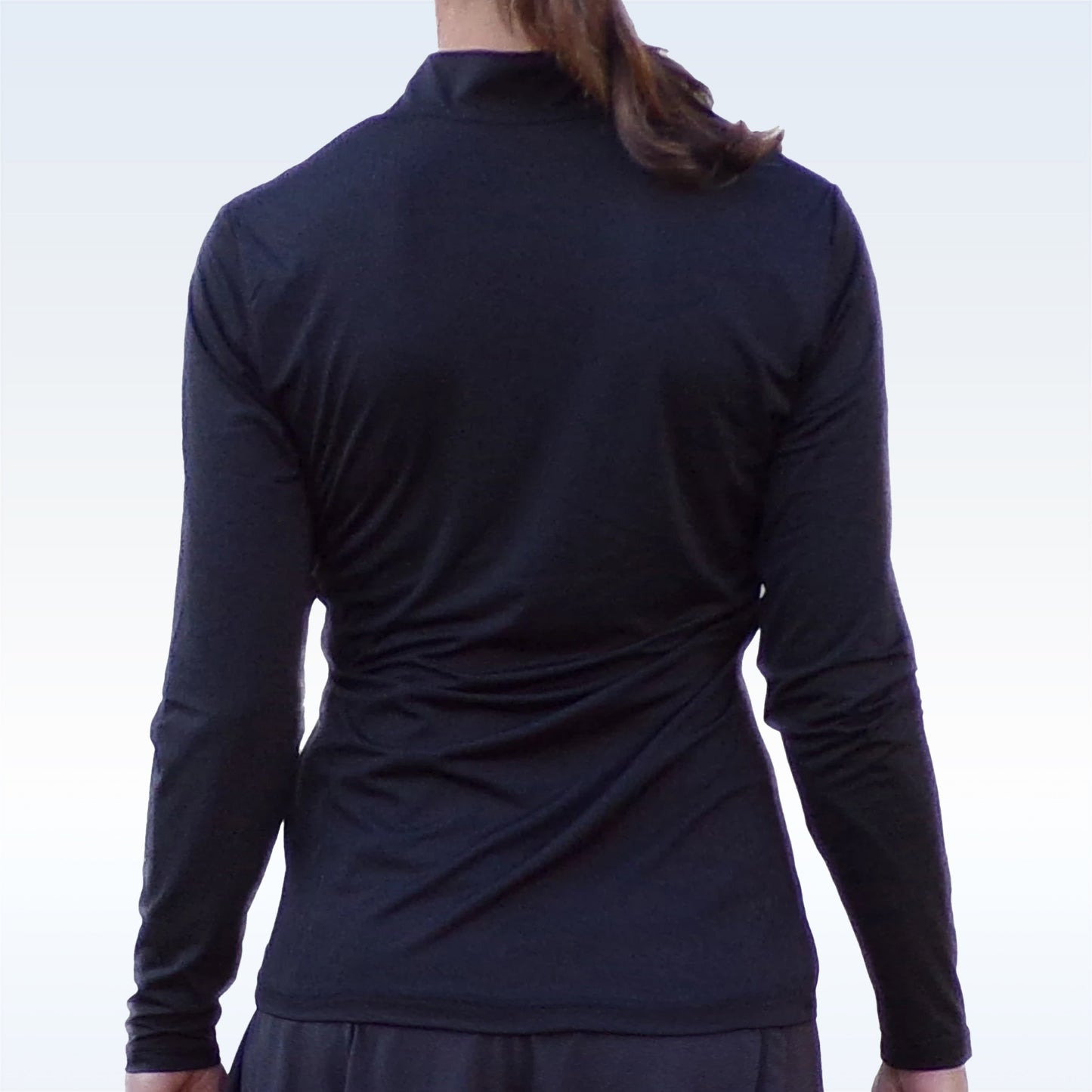 A person with brown hair in a ponytail is shown from the back, standing upright with arms relaxed, wearing the Pickleball Bella PB 1/4 Zip Long Sleeve Black against a plain light background.