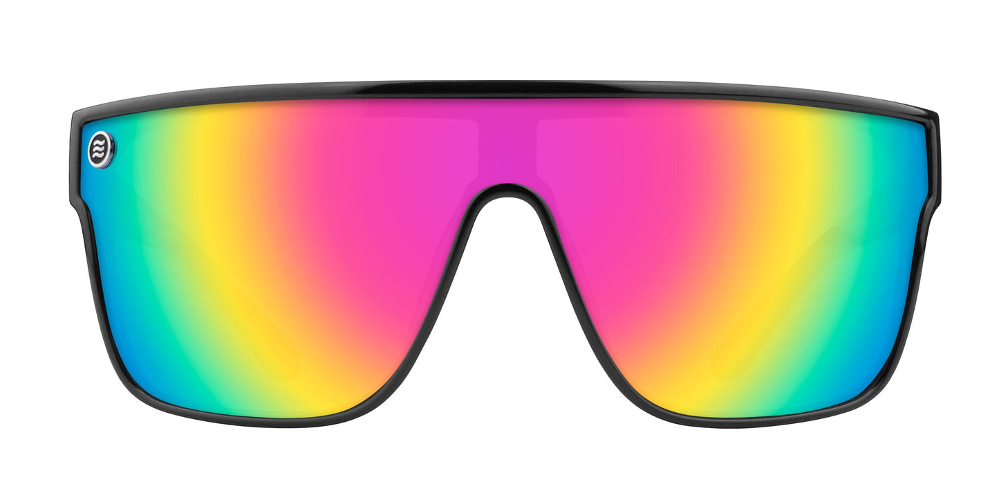 The Noosa by Neven Eyewear features oversized, single-shield sunglasses with an impact-resistant lens in pink, yellow, green, and blue gradient. The bold black frame wraps around the colorful UV400-protected lens for a modern look.
