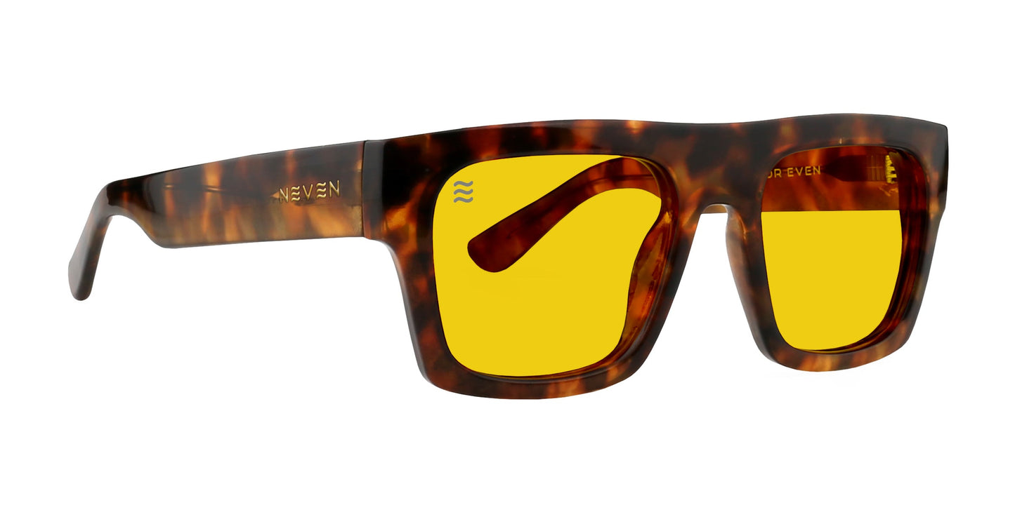 The Amar by Neven Eyewear features thick, rectangular tortoise shell frames with vibrant yellow lenses and wide arms accented by a subtle gold logo—blending bold modern style with retro flair for standout fashion eyewear.