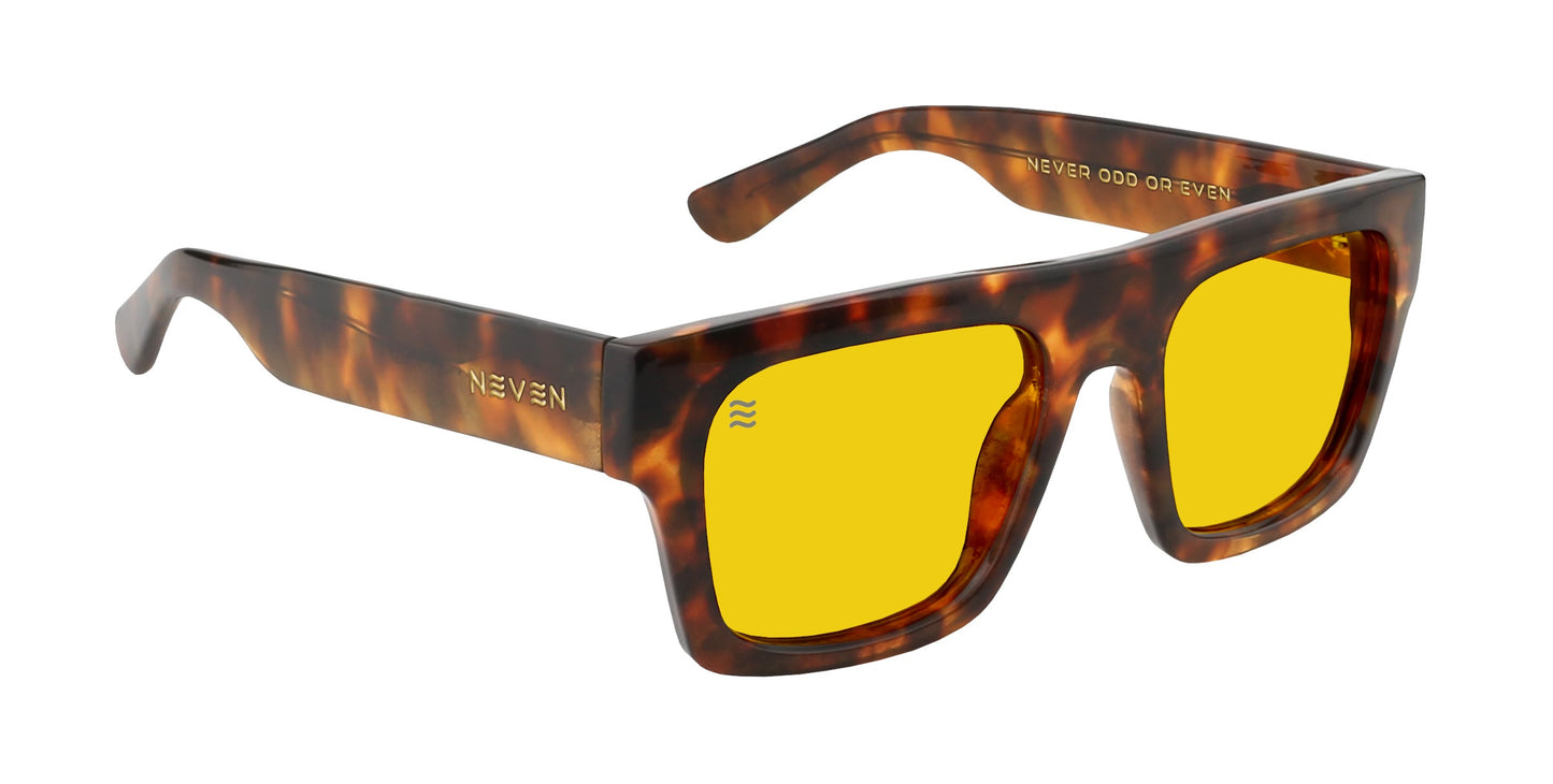 The Amar by Neven Eyewear features rectangular sunglasses with thick, glossy tortoise shell frames and bold yellow lenses. The left temple displays NEVEN in gold; the right reads NEVER ODD OR EVEN.