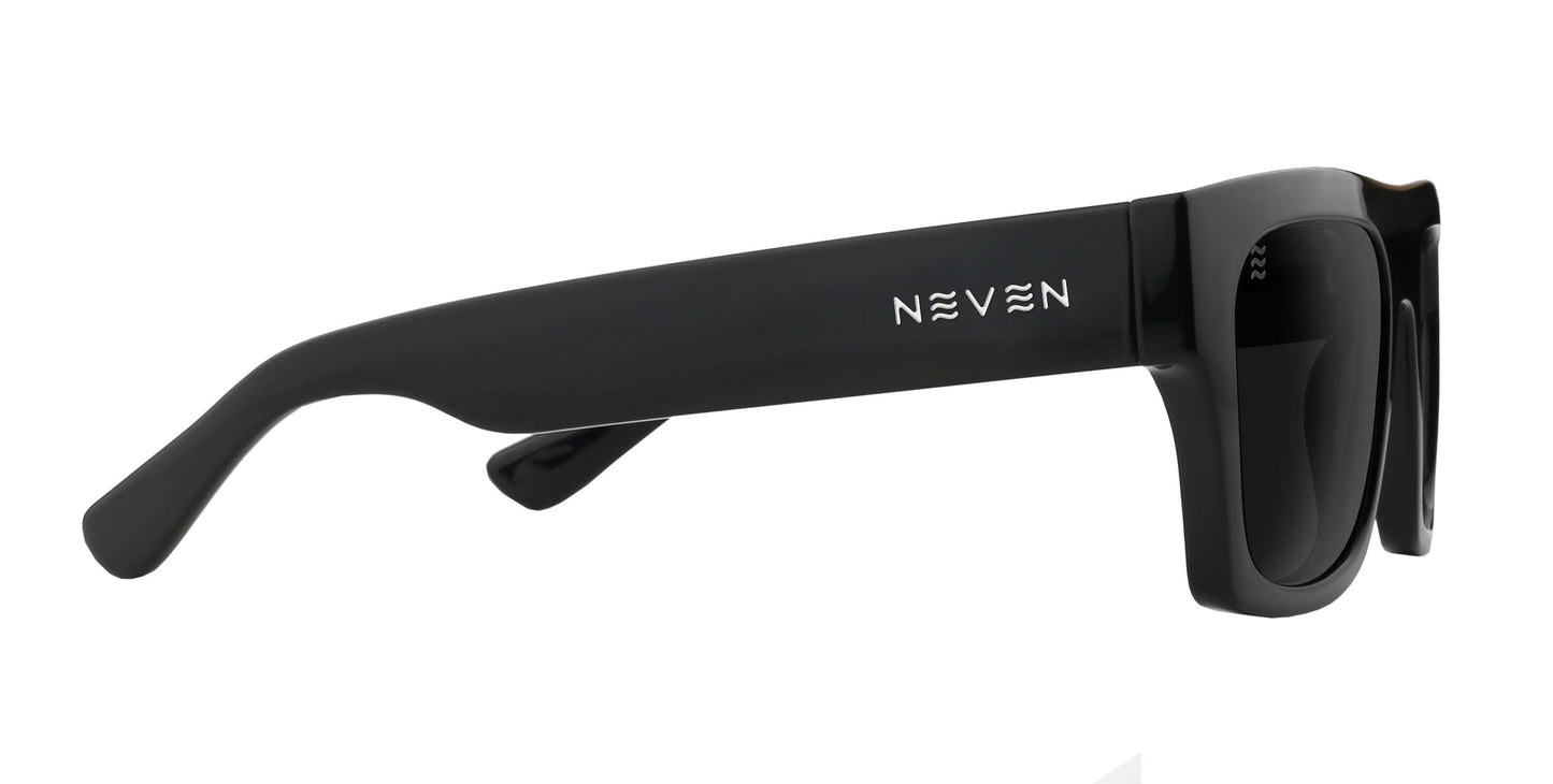 Close-up side view of black Royce polarized sunglasses by Neven Eyewear, featuring thick frames, dark UV400-protected lenses, and the partially visible NEVEN logo on the side arm. The sunglasses rest on a white surface.