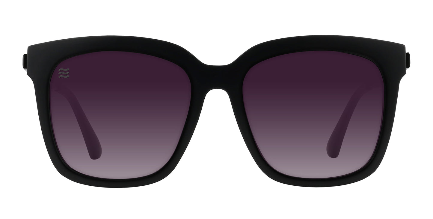 The Lido sunglasses by Neven Eyewear feature matte black frames and large, square dark purple gradient lenses with polarized UV400 protection, combining a sleek modern design with a smooth matte finish.