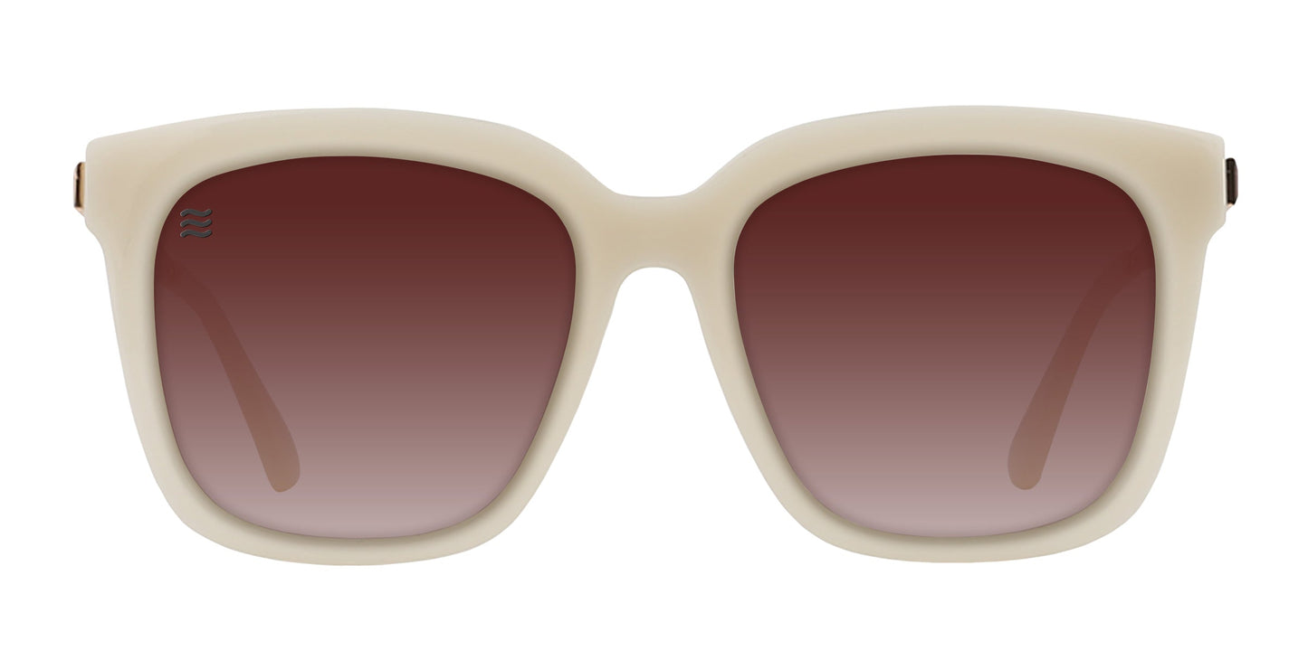 Sand Dollar by Neven Eyewear: polarized sunglasses with thick, off-white square frames, large gradient brown lenses, a modern retro-inspired style, and an emblem on the upper left lens.