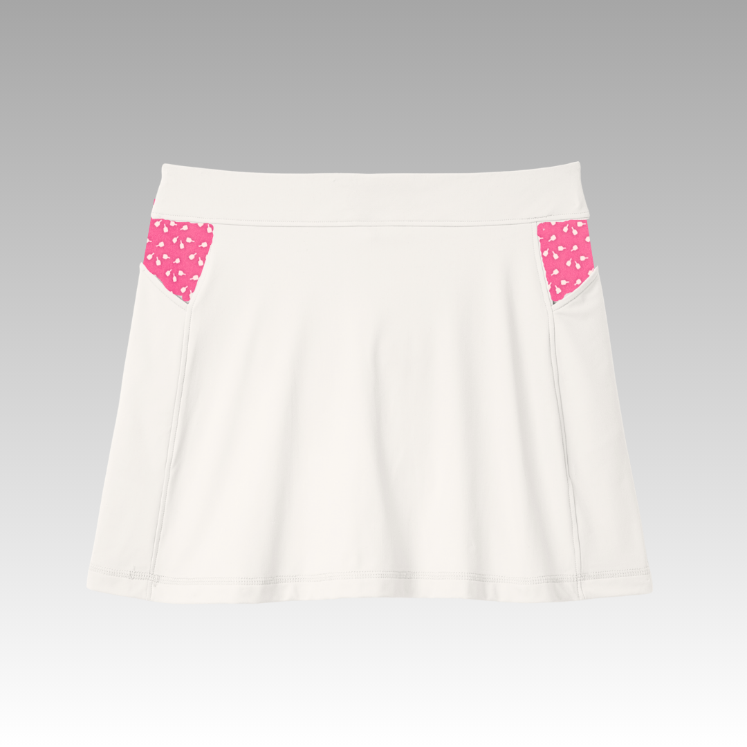 The Sammy Skort 2.0 from Playly Store is a white high-waisted skort with a wide waistband, two small pink side pockets, and a white heart pattern. Subtle stitching and CoolFlow fabric ensure comfort on a light gray gradient background.