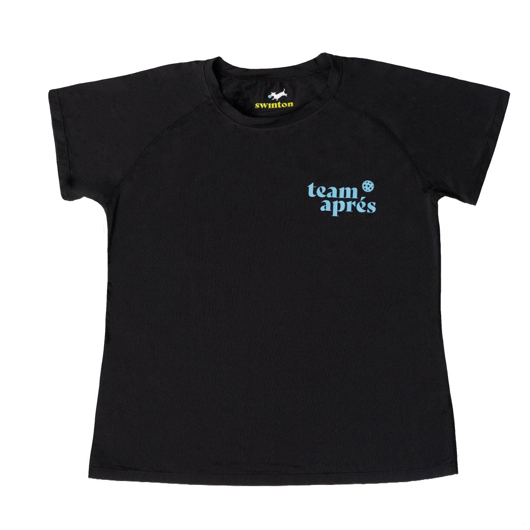 The Women's Aprés Pickleball Performance Shirt by Swinton Pickleball is a black crew-neck tee with "team après" in light blue on the left chest, featuring moisture-wicking fabric and a visible inner Swinton brand tag.