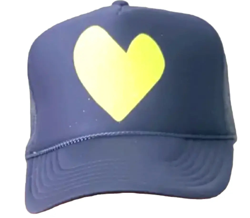 The Heart Trucker Hat - Navy by Runway Athletics features a bold yellow heart graphic on the front, a curved brim with visible stitching, and classic trucker style. Shown against a plain white background.