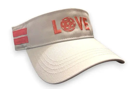 The Runway Athletics Pickleball Visor in white & pink is a cotton canvas sports cap with sun protection, two pink side stripes, and "LOVE" on the front—featuring a pink tennis ball as the "O.