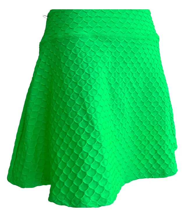 The Runway Athletics 16.5" Nola Scallop Skirt in lime features a vibrant green, flared A-line silhouette with a mermaid-inspired scallop pattern and a moisture-wicking under-short for comfort and ease of movement.