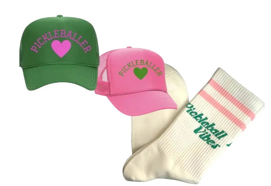 The Pickleballer Vibes Gift Pairing by Runway Athletics includes a green “PICKLEBALLER” trucker hat with a pink heart, a pink cap with green heart, and white Pickleball Vibes socks—ideal for any pickleball fan!.
