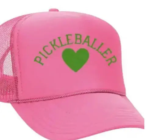 The Pickleballer Trucker Hat by Runway Athletics features a bright pink design, a green heart centerpiece with "PICKLEBALLER" arched above, mesh back, and curved bill for a sporty, playful look.