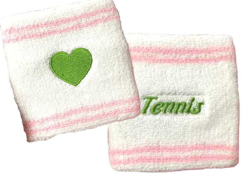 The Runway Athletics Runway Sweatband Set features two white cotton terry wristbands with pink stripes—one has a green embroidered heart, the other says "Tennis" in green cursive. Both are soft, absorbent, and shown on a white background.
