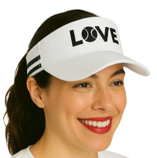 A smiling woman with red lipstick wears the Runway Athletics Striped Cotton Canvas LOVE Visor in white, featuring “LOVE” in bold black letters with a tennis ball for the O, two black stripes, and her dark hair pulled back.
