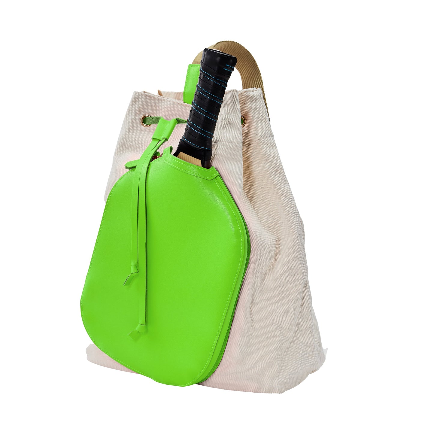 A beige canvas sling bag with light brown leather straps features the Pickleball Bella PB Neon Gecko Green Pickleball Drawstring Bag attached to the front, with a black racket handle peeking out. The background is white.