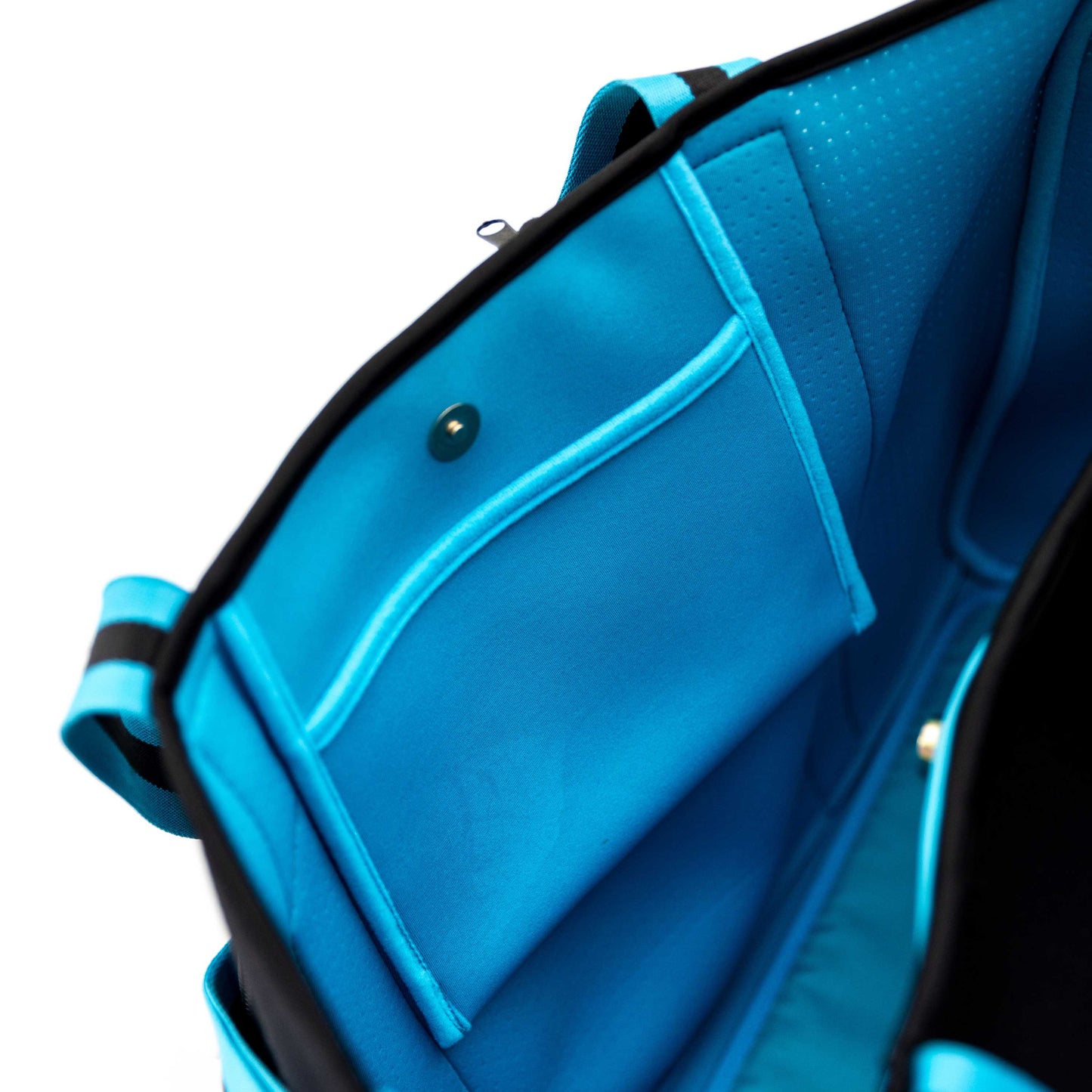 A close-up of the Swinton Pickleball XL Pickleball Tote Bag - Black shows its neoprene duffel design with visible edges and straps, an open pocket with snap button closure, soft lining, and perforated texture inside.