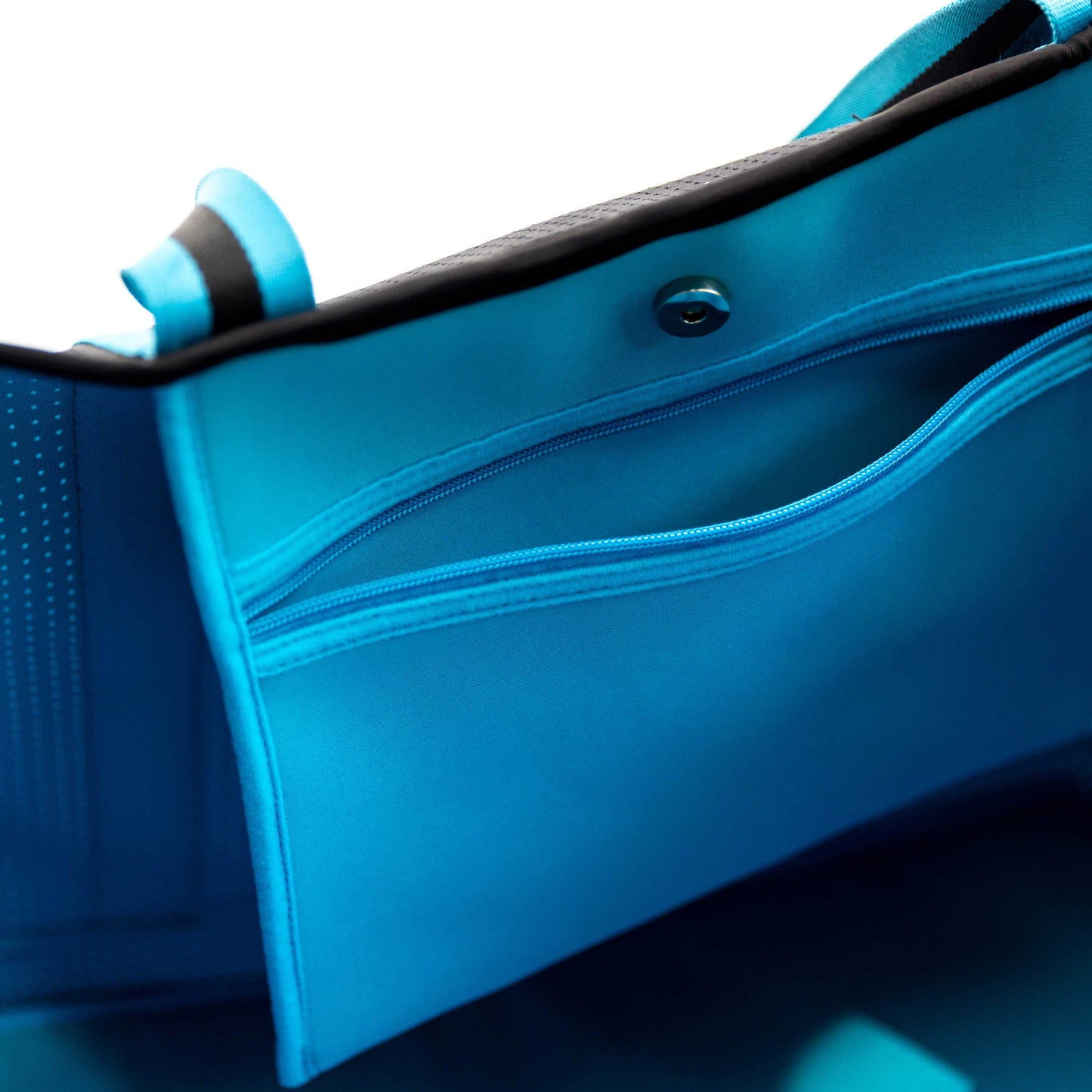 Close-up of the XL Pickleball Tote Bag - Black by Swinton Pickleball, featuring a zippered pocket with smooth lining, sturdy handles, and snap button closure—all details highlighted against a white background.