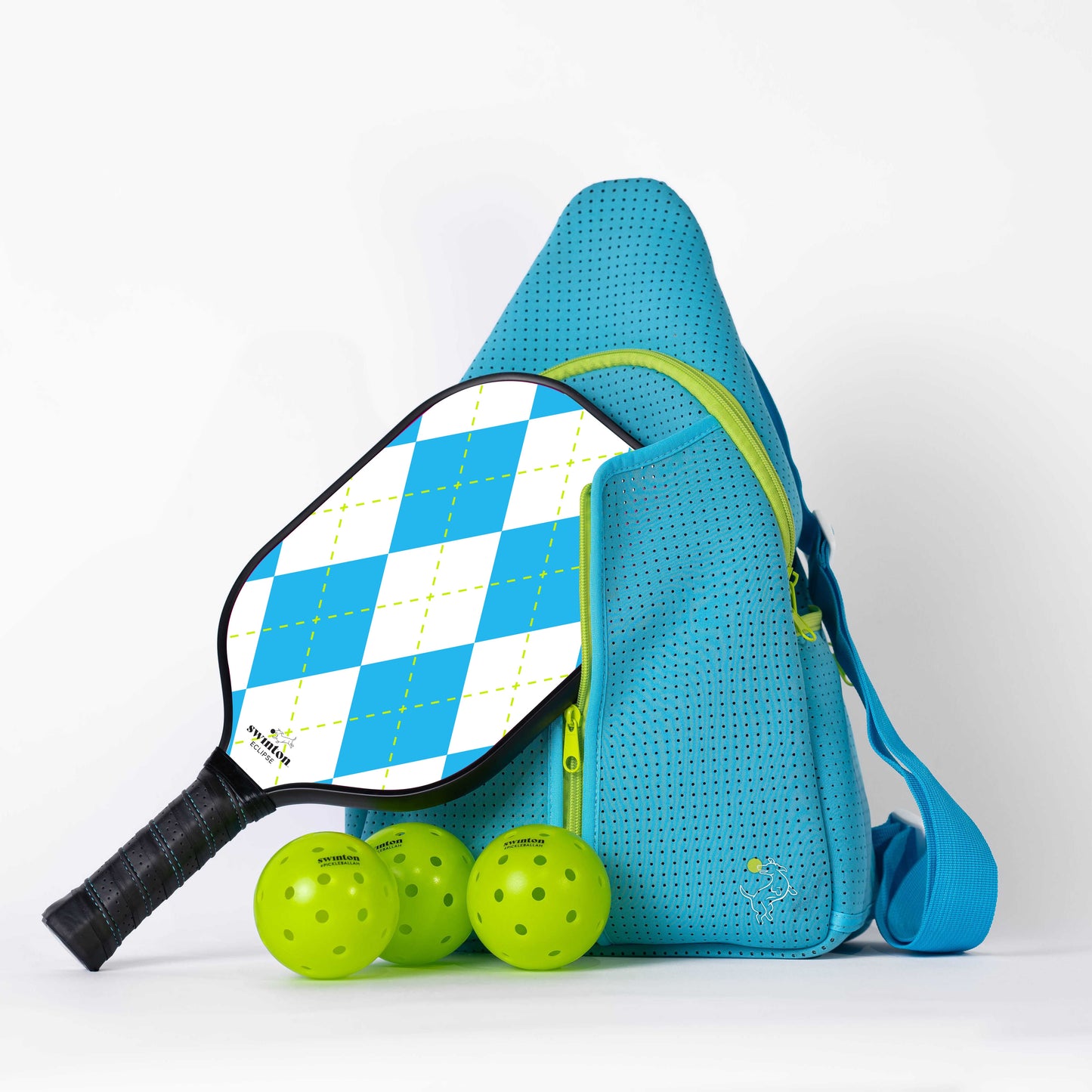The Swinton Pickleball Starter Bundle - Blue features a blue perforated bag with a shoulder strap, a blue and white diamond-patterned paddle leaning against it, and three neon green pickleballs at the base—a perfect starter set.
