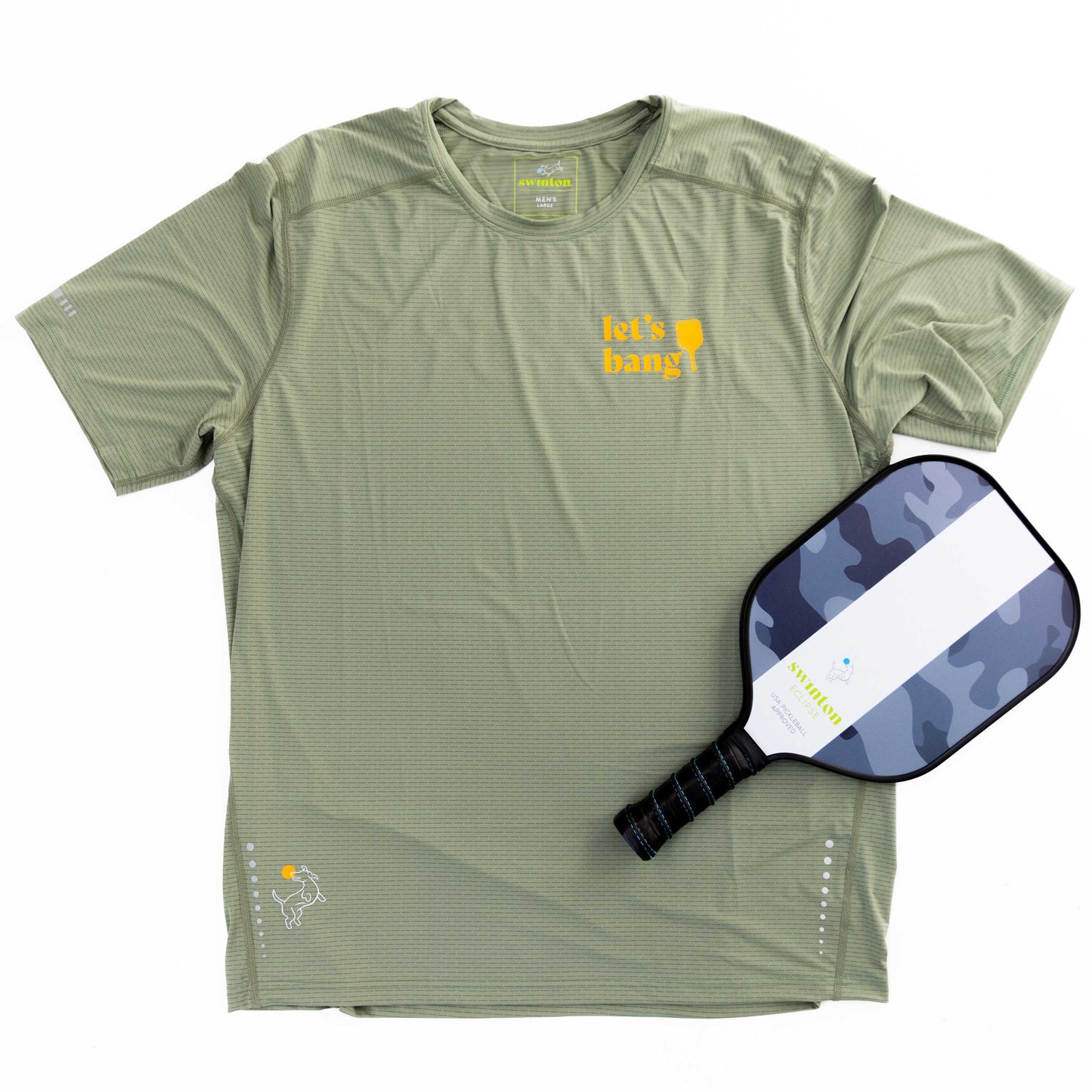 The Swinton Pickleball Women's Banger LUX Performance Shirt in light green features "lets bang!" and a yellow paddle icon on the chest, subtle stripes, performance material, and a white dog logo at the hem. Shown beside a black/gray camo pickleball paddle.
