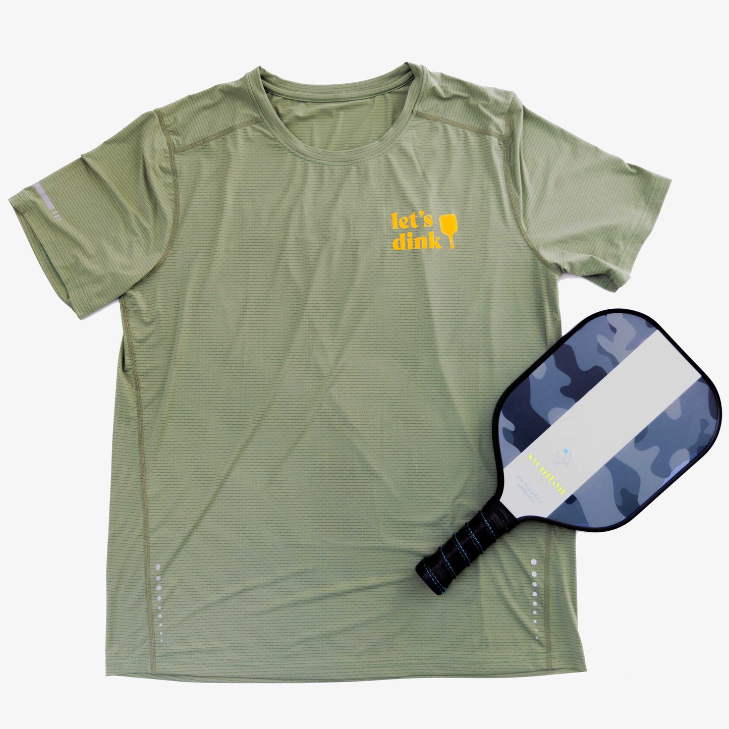 The Swinton Pickleball Women's Dinker LUX Performance Shirt in light green, featuring "lets dink!" and a yellow paddle graphic, is paired with a blue-grey-white camo paddle—ideal stylish gear for any pickleball doubles team.