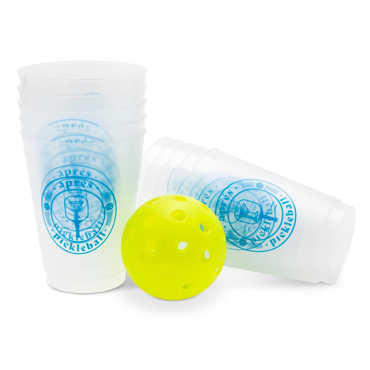 A stack of Aprés Pickleball Reusable Party Cups by Swinton Pickleball, featuring blue circular logos, stands upright next to another cup on its side with a yellow perforated pickleball in front—ideal as a pickleball gift.